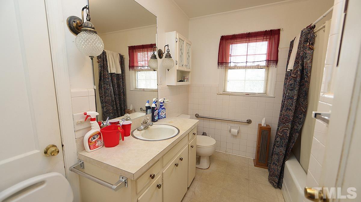 819 Woodland Road Raleigh, NC 27603 - Photo 12 of 16 a bathroom with a sink toilet vanity and tub