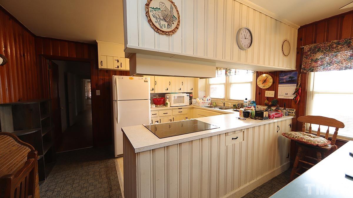 819 Woodland Road Raleigh, NC 27603 - Photo 5 of 16 a kitchen with a sink and a refrigerator