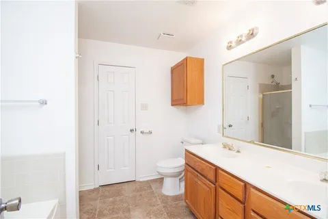 a spacious bathroom with a granite countertop sink mirror and a toilet