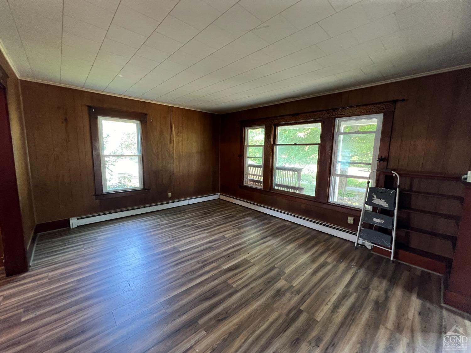 163 Spring Street Catskill, NY 12414 - Photo 15 of 36 an empty room with wooden floor and windows
