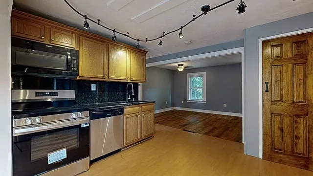 a kitchen with stainless steel appliances granite countertop a stove and a microwave