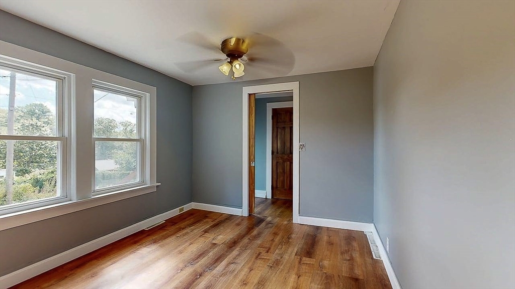 10 Overlook Avenue Charlton, MA 01507 - Photo 21 of 40 an empty room with wooden floor chandelier and windows