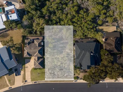 an aerial view of a house with a yard and parking space