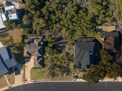 an aerial view of a house with a yard and parking space