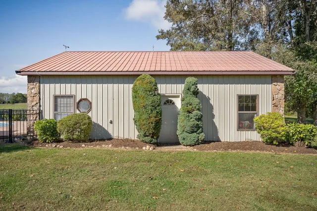 a view of house with yard and sitting area