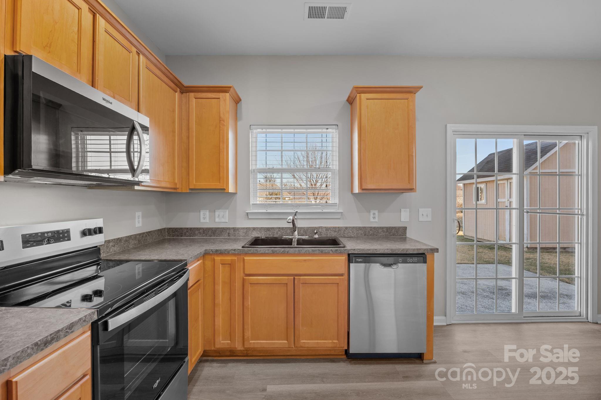 3422 Burnage Hall Road Harrisburg, NC 28075 - Photo 21 of 42 a kitchen with stainless steel appliances granite countertop a sink stove and microwave