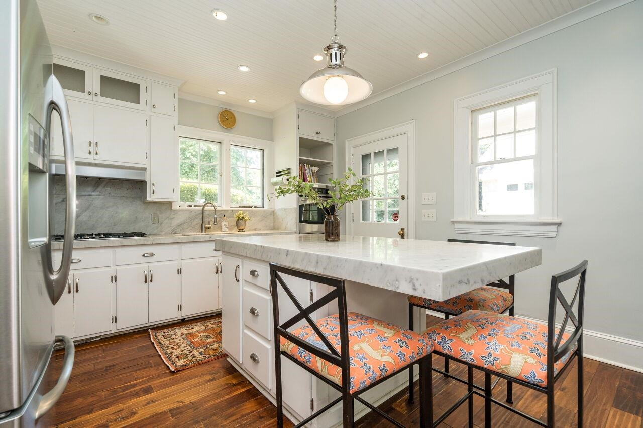 13 Furches Street Raleigh, NC 27607 - Photo 14 of 37 a kitchen with stainless steel appliances white cabinets and wooden floor