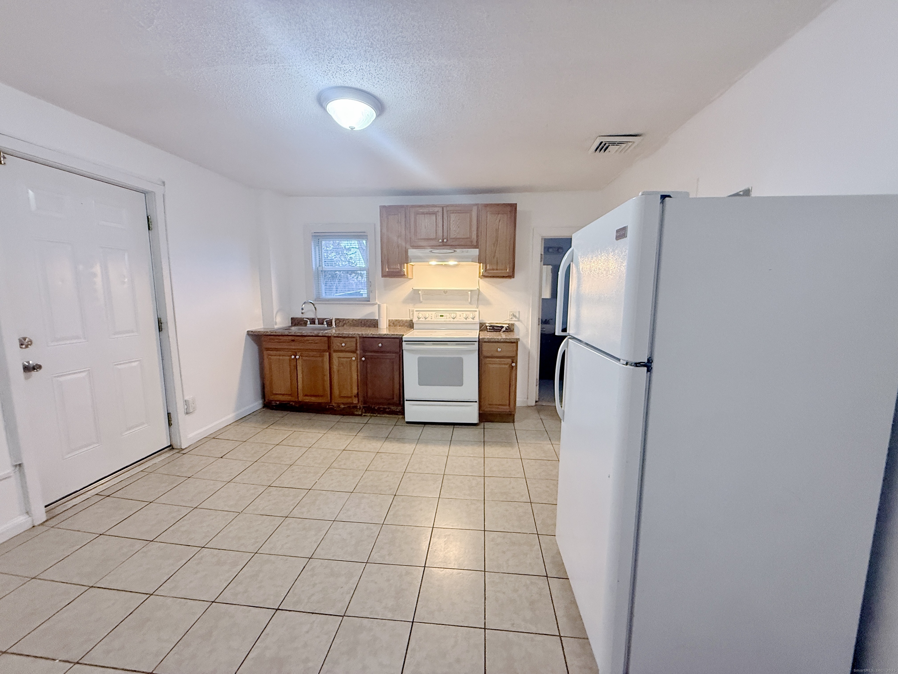 12 South Street New Britain, CT 06051 - Photo 4 of 9 a kitchen with granite countertop a refrigerator and a stove top oven
