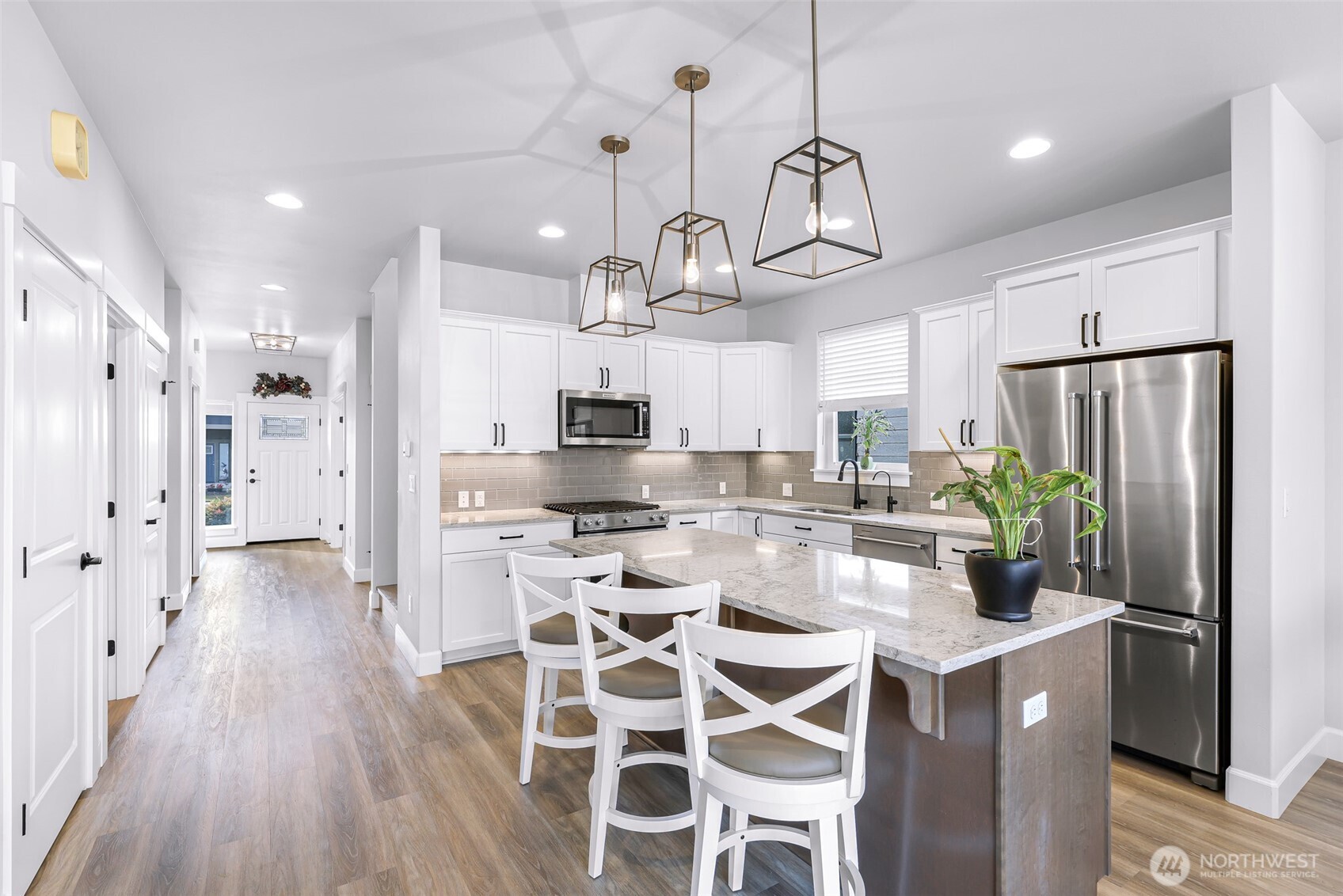 1396 Woods Point Loop Ferndale, WA 98248 - Photo 8 of 32 a kitchen with stainless steel appliances kitchen island granite countertop a refrigerator a stove a sink and white cabinets with wooden floor