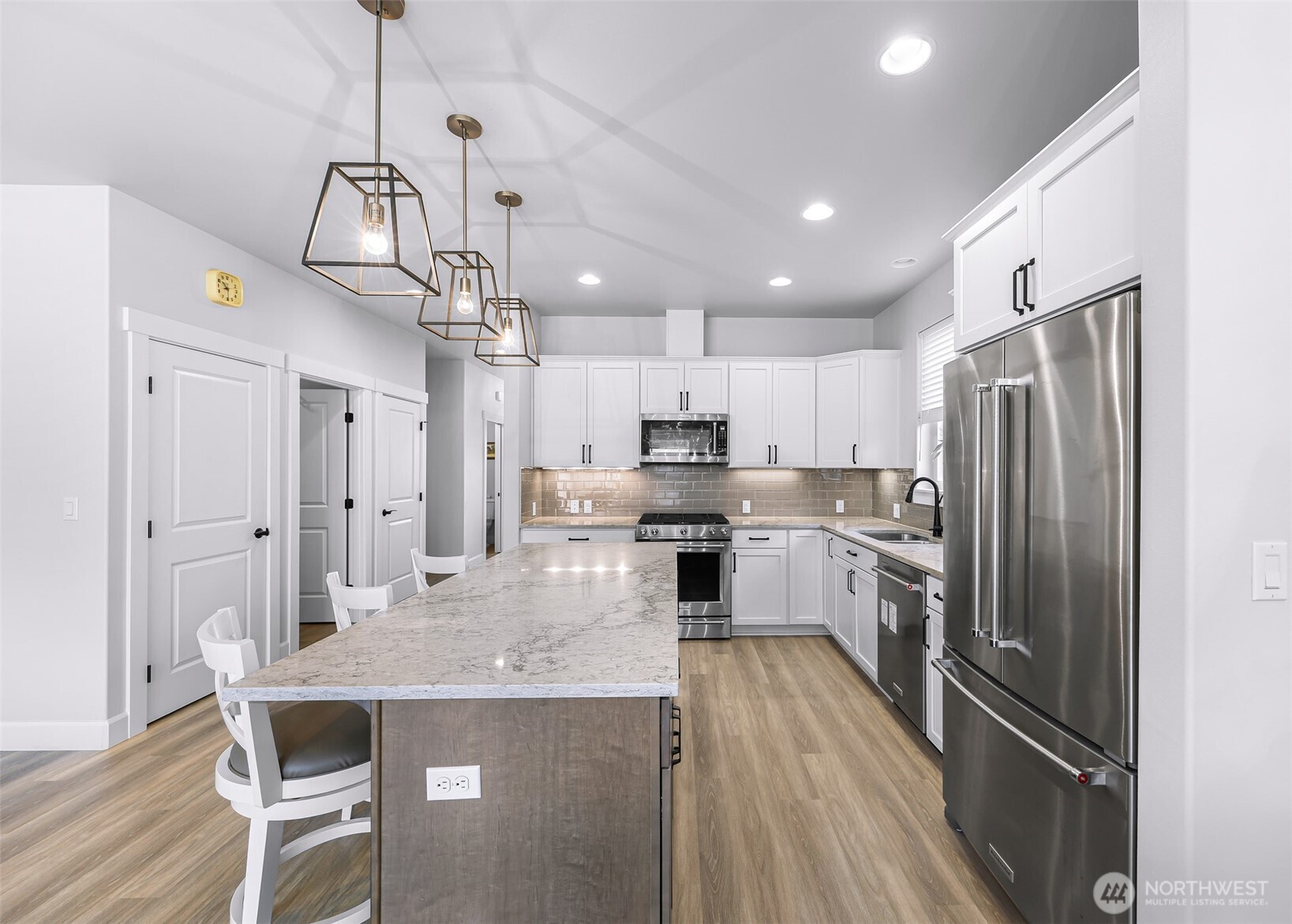 1396 Woods Point Loop Ferndale, WA 98248 - Photo 9 of 32 a kitchen with kitchen island a refrigerator stove microwave and cabinets