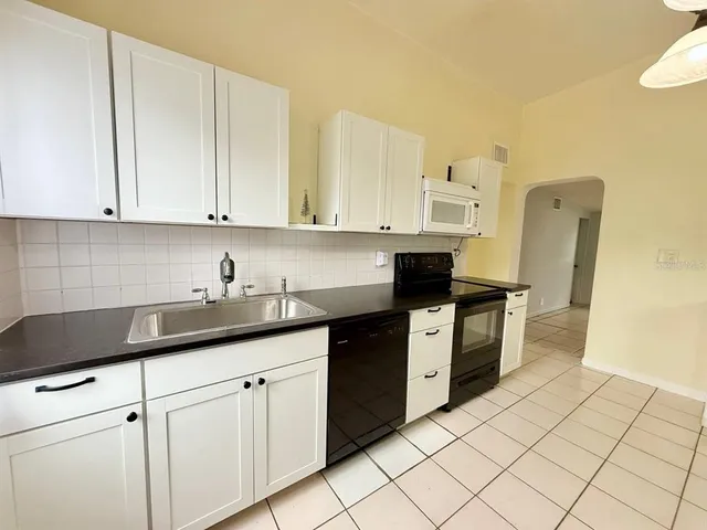 a kitchen with granite countertop a sink stainless steel appliances and cabinets