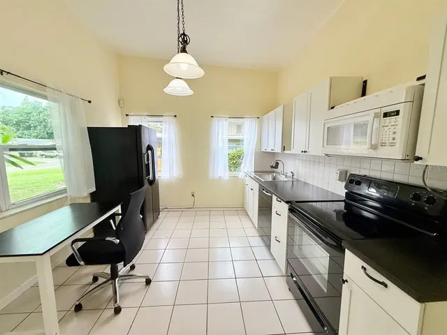 a kitchen with stainless steel appliances granite countertop a stove a sink and a microwave