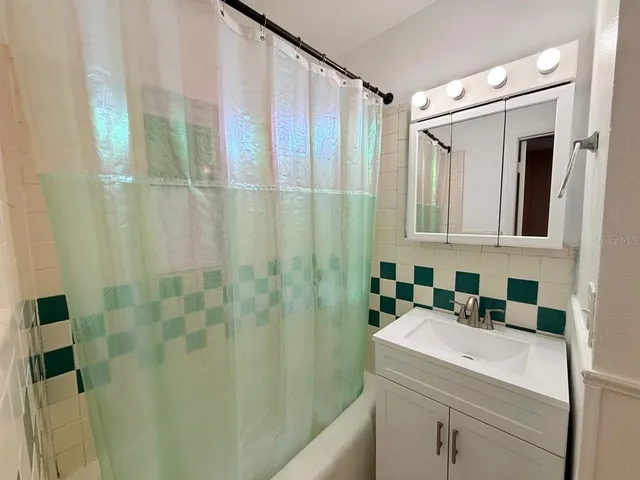 a bathroom with a sink a mirror and a shower curtain