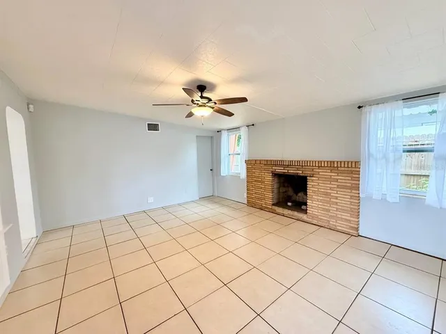 a view of an empty room with a fireplace and a window