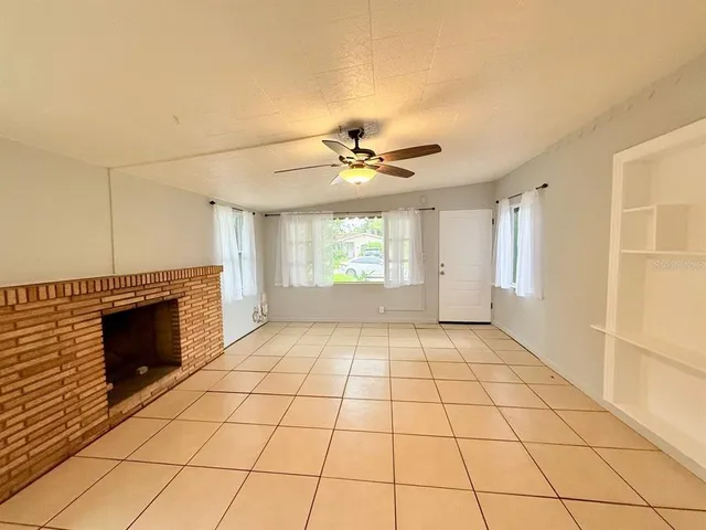 a view of an empty room with a fireplace and a window