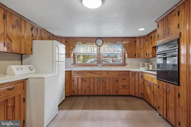 a kitchen with granite countertop a refrigerator stove top oven and sink