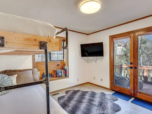 a view of an empty room with wooden floor and windows