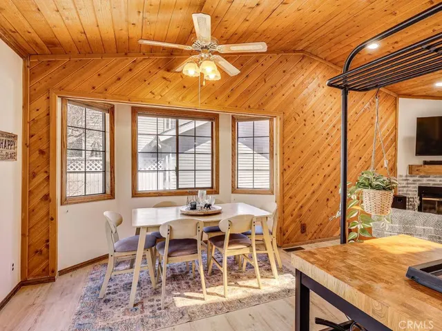 a dining room with furniture a floor to ceiling window and wooden floor