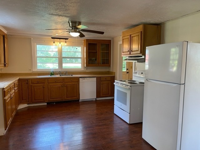 301 Bennett Street Decherd, TN 37324 - Photo 14 of 41 a kitchen with wooden floors and white stainless steel appliances