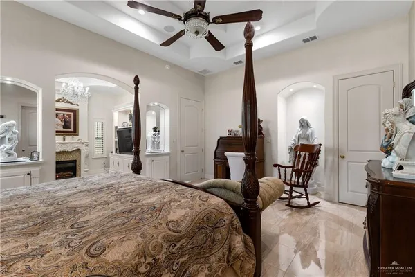 a bedroom with a bed a chair and fireplace