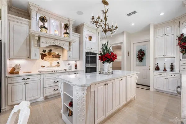 a kitchen with cabinets a sink dishwasher and a fireplace with wooden floor