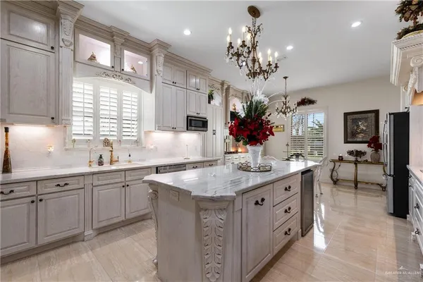 a view of a kitchen island a chandelier and living room