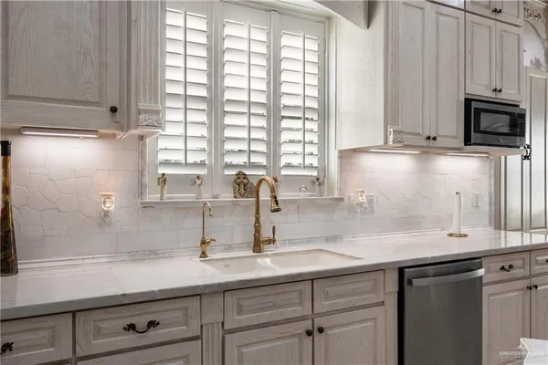 a kitchen with stainless steel appliances a sink a stove and cabinets