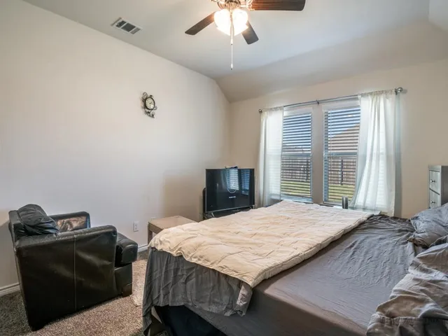 a bedroom with a bed couch and window