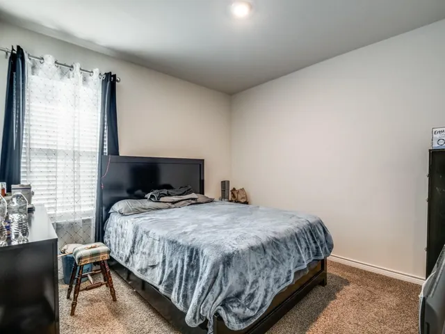 a bedroom with a bed and a mirror on dresser