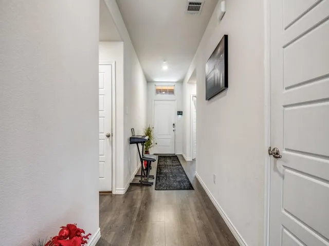 a view of a hallway with wooden floor and staircase