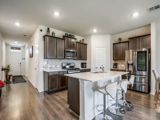 a kitchen with a stove a table and chairs