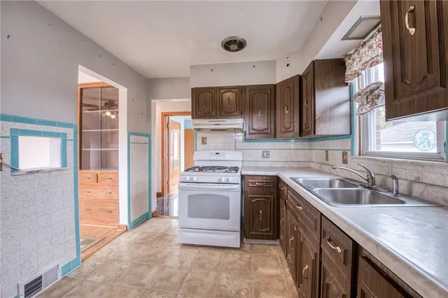 a kitchen with a sink stove top oven and refrigerator