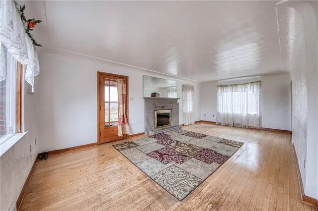 an empty room with windows and fireplace