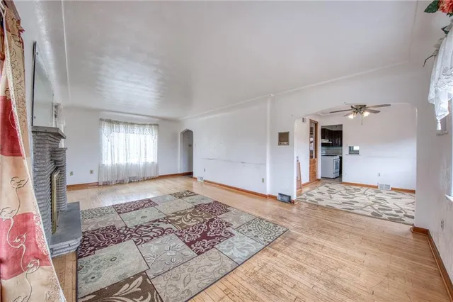 a view of a big room with a fireplace and windows