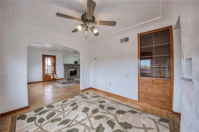 a view of an empty room with wooden floor and cabinet