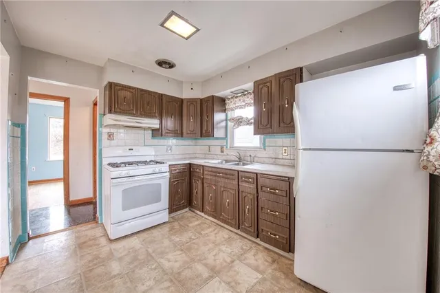 a kitchen with stainless steel appliances granite countertop a refrigerator sink and stove