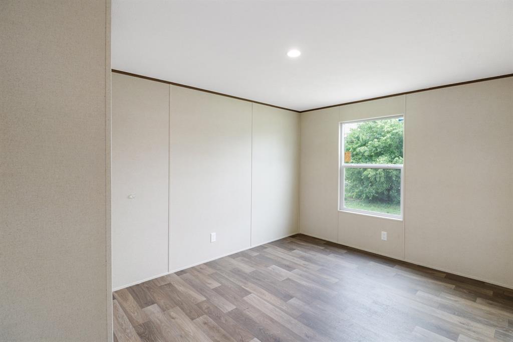 708 West 8th Street Coleman, TX 76834 - Photo 20 of 25 an empty room with wooden floor and windows