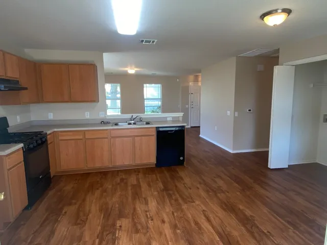 a large kitchen with wooden floors and stainless steel appliances