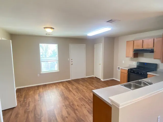 a view of kitchen with stainless steel appliances cabinets and wooden floor
