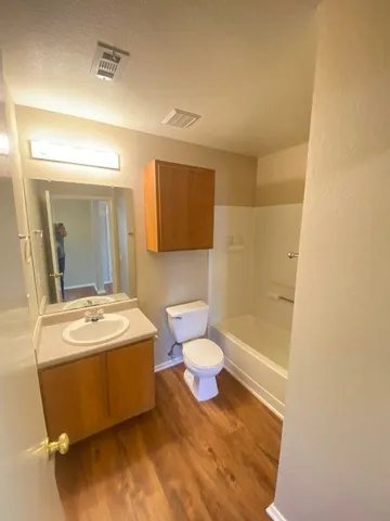 a bathroom with a sink mirror vanity and toilet