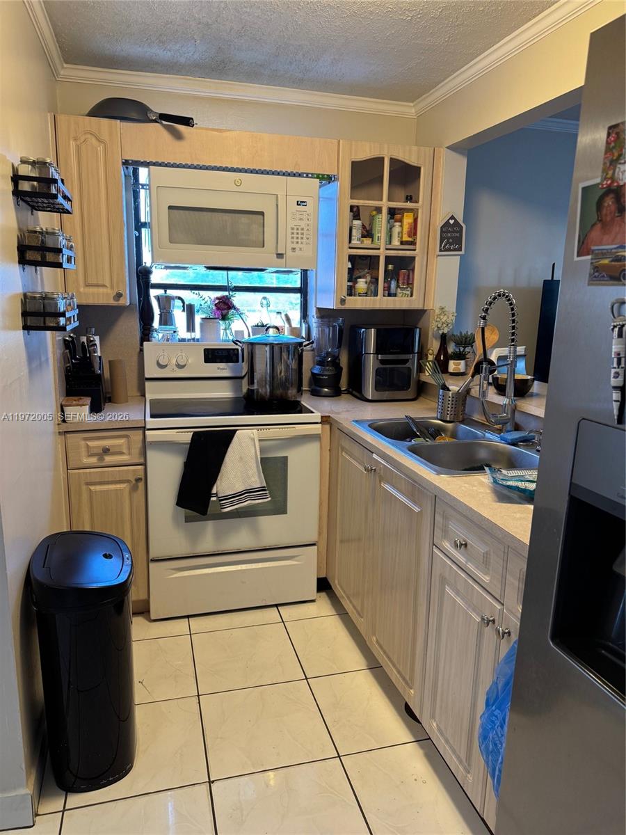 952 East 19th Street Hialeah, FL 33013 - Photo 6 of 13 a kitchen with stainless steel appliances granite countertop a stove a sink and a microwave