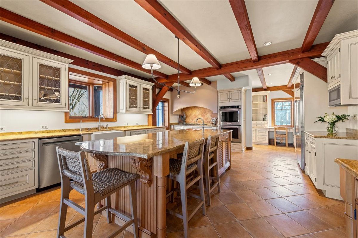 236 Steeplechase Road Barrington Hills, IL 60010 - Photo 16 of 69 a dining room with stainless steel appliances kitchen island granite countertop a table chairs and a large window