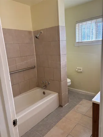 a white bath tub sitting next to a white toilet and a sink