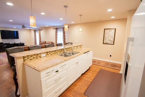 a large kitchen with a large counter top space a sink and a large window