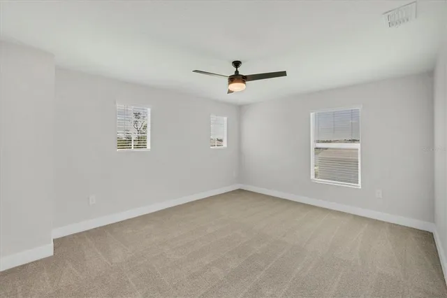 a sign board with tall yellow house in the background