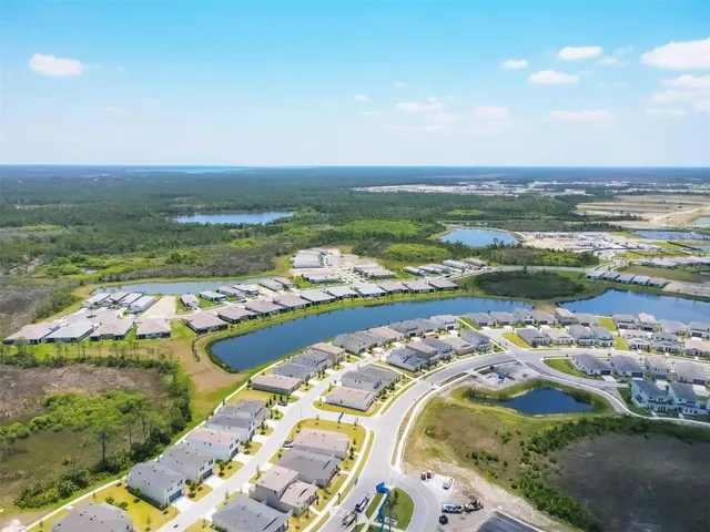 an aerial view of ocean and residential houses with outdoor space
