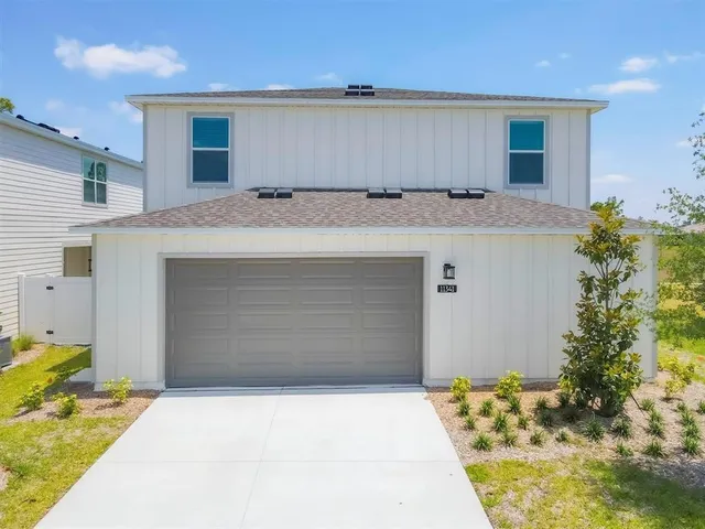 a view of a building with a yard and sitting area