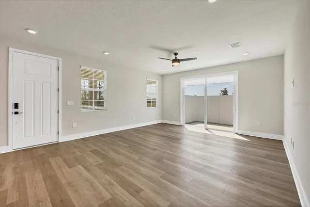 a kitchen with stainless steel appliances granite countertop a sink a stove a refrigerator and white cabinets with wooden floor