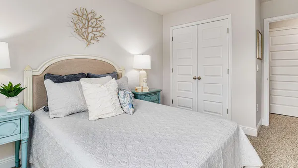a bedroom with a bed and a potted plant