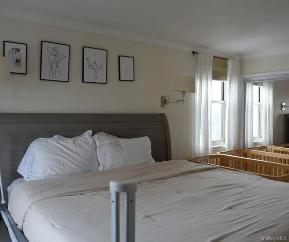 a bedroom with a bed and painting on the wall